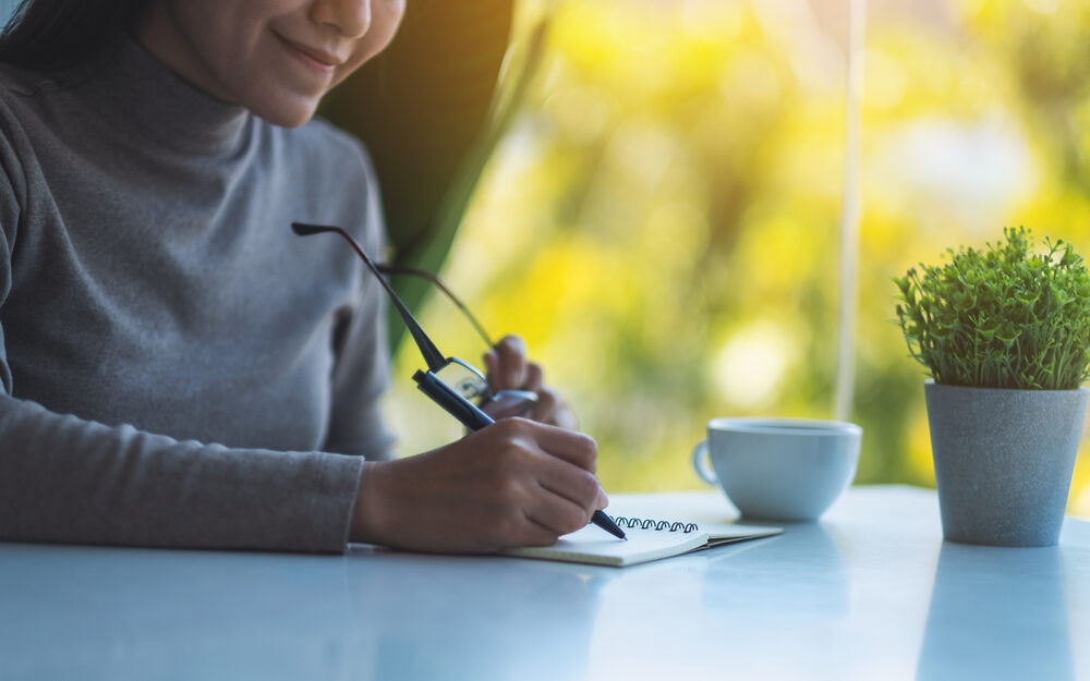 Eine Person macht sich Notizen in ein Heft